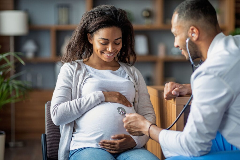 Pregnant african american woman visiting doctor gynecologist Cradle to Career